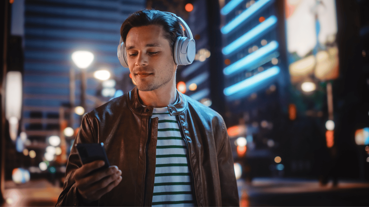 a man wearing headphones and looking at a phone