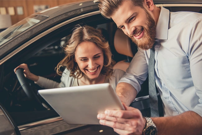 a man and a woman looking at a laptop