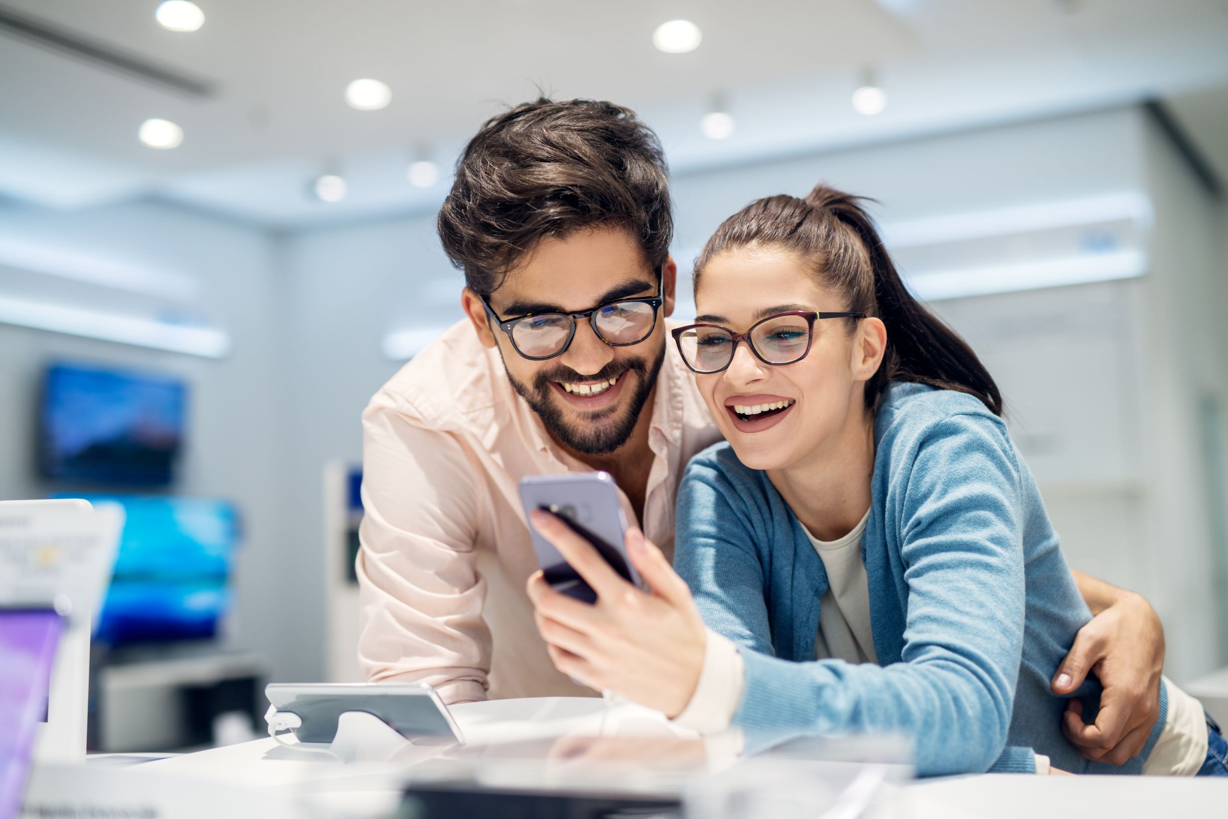 Man and woman shopping for a mobile phone in a store