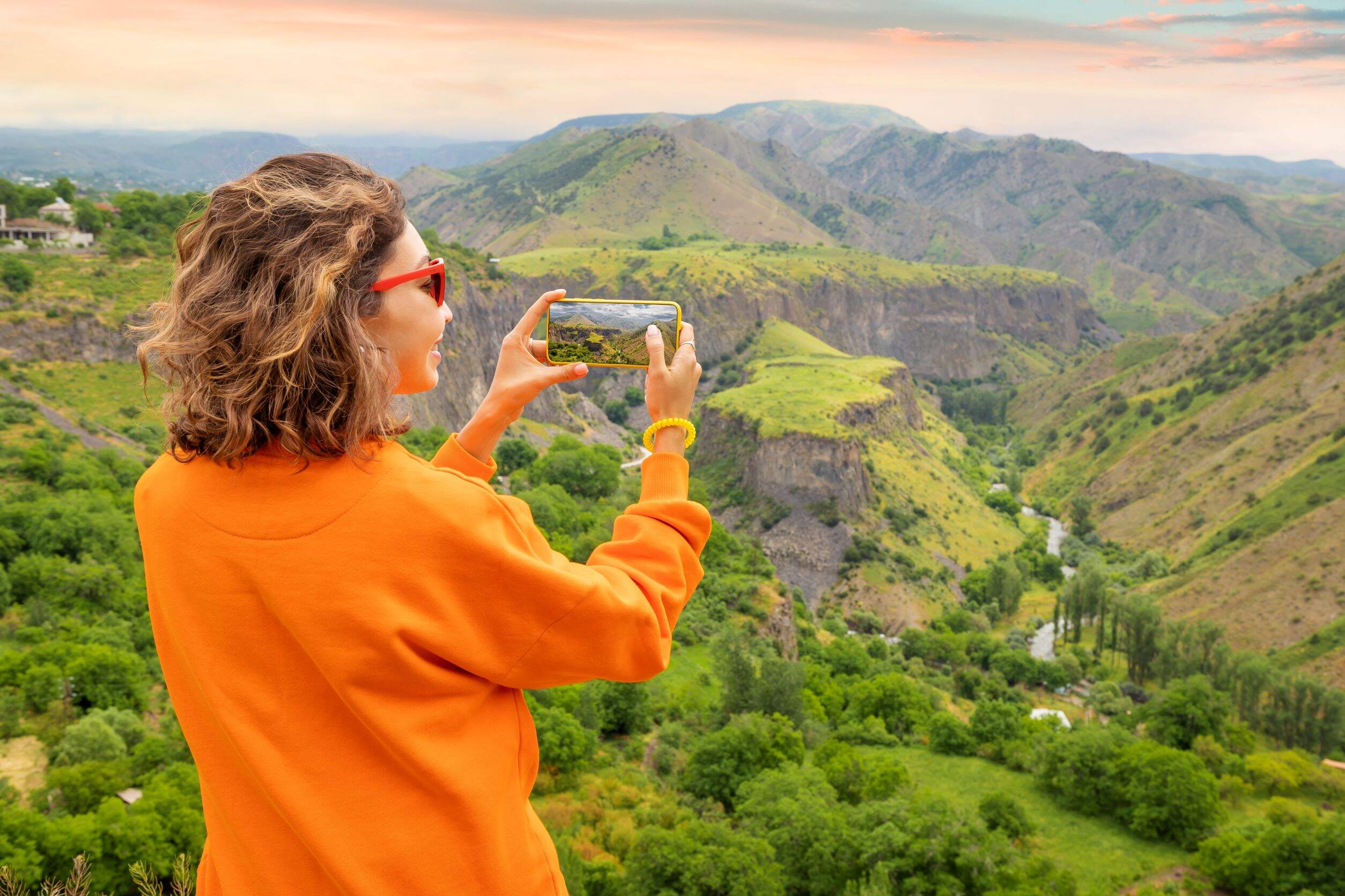 Woman taking a mobile photo of mountains