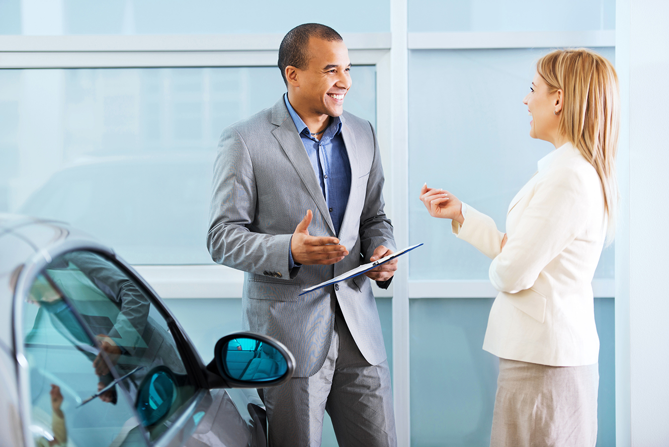 two people at a car dealership-auto reinsurance